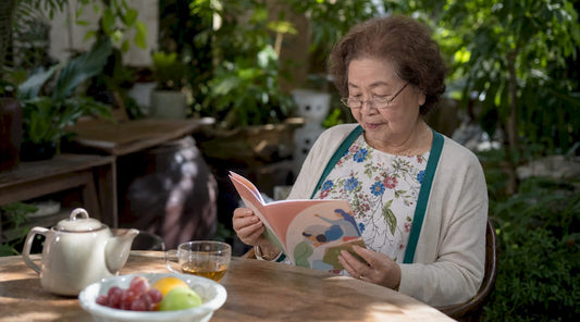 Elderly woman reading mineral guide at kitchen table